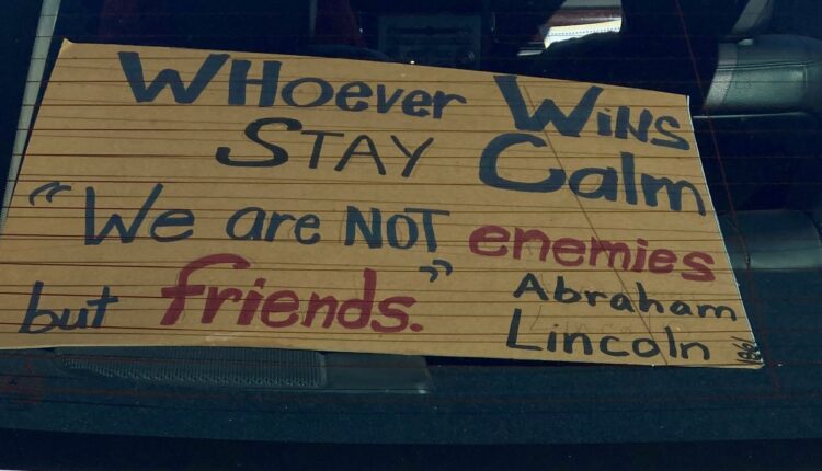 A sign made by Vicki Farrell, 65, in the back of her car at the Aragon Precinct in Virginia Beach urging calm following the 2020 election. (Roger Chesley/ For the Virginia Mercury)
