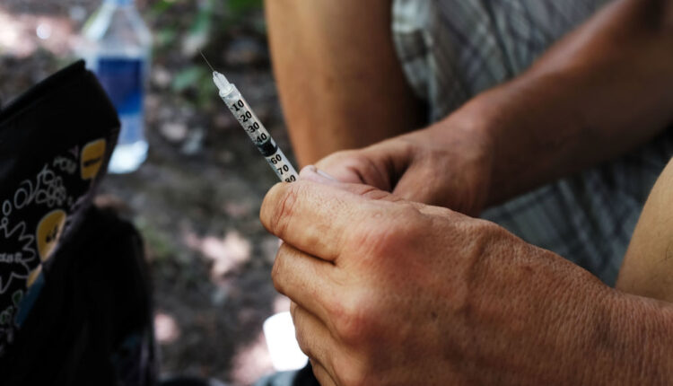 A man prepares to inject himself with heroin (Photo by Spencer Platt/Getty Images).